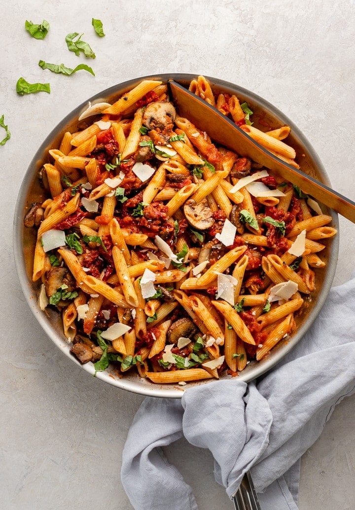 Skillet filled with penne alla vodka with mushrooms and sun-dried tomatoes.