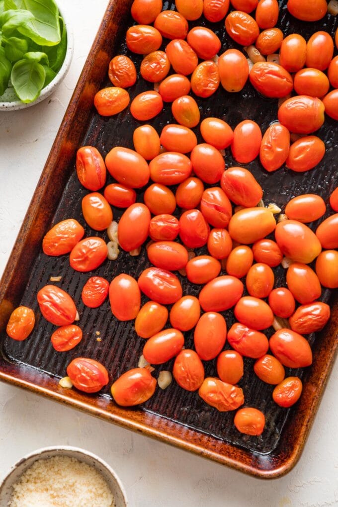 Close-up of lightly blistered cherry tomatoes just roasted on a rimmed sheet pan.