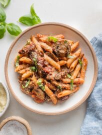 Small pasta bowl full of a vegetarian vodka pasta with mushrooms and sun-dried tomatoes.