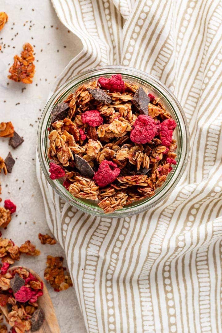 A small jar filled with raspberry chocolate chunk granola.