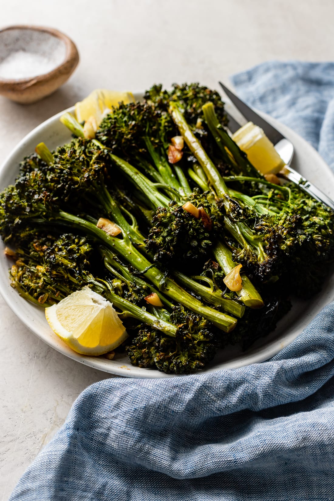 Close-up image of roasted broccolini tips, slightly charred.