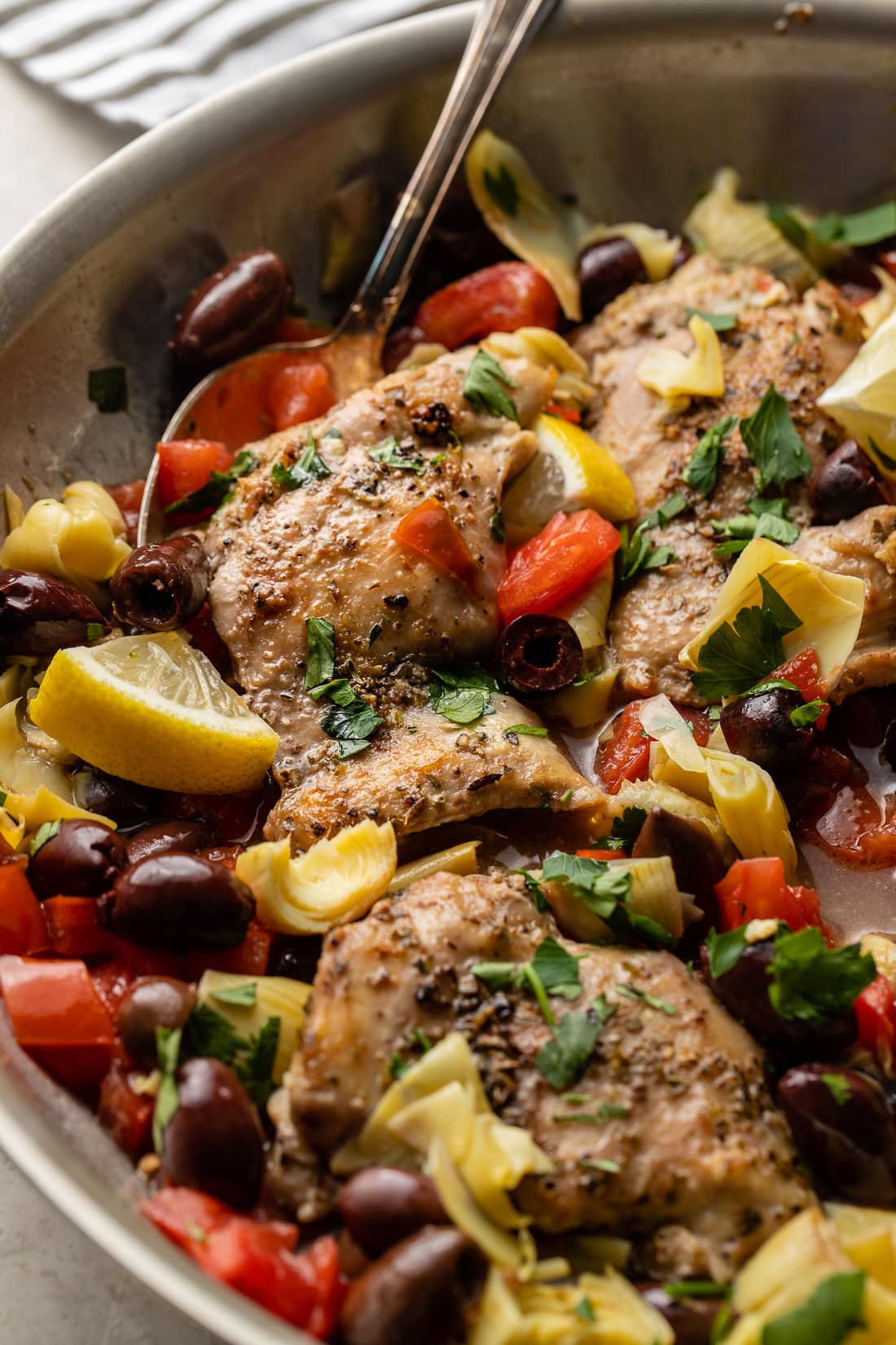 Close-up of seasoned Greek chicken cooked in a skillet.