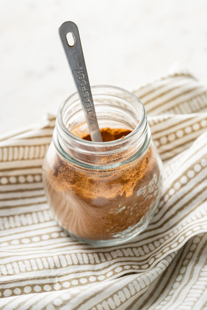 A small glass jar filled with homemade pumpkin pie spice.