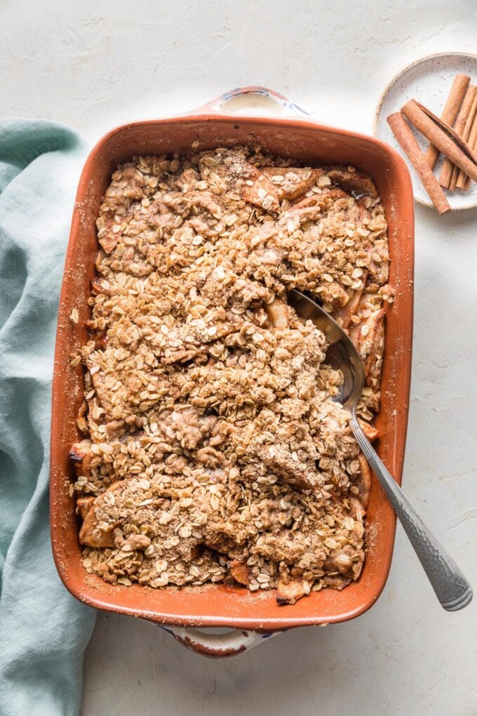 A spoon digging into a freshly-baked apple crisp.