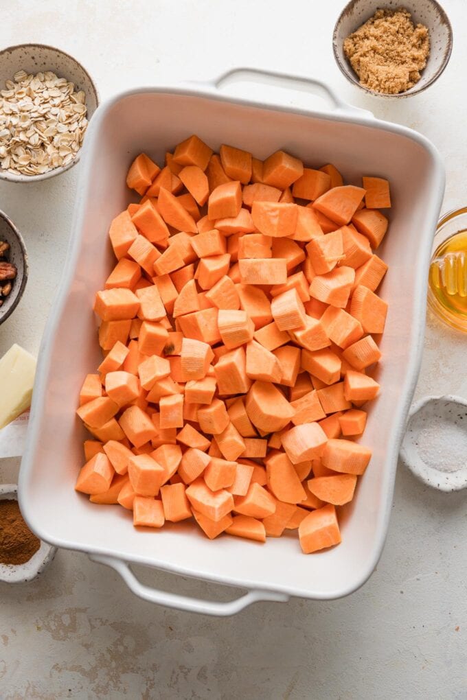 Cubed sweet potatoes in a 9x13-inch baking dish.