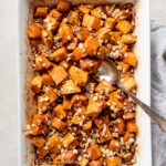 Baking dish filled with baked honey butter sweet potatoes.