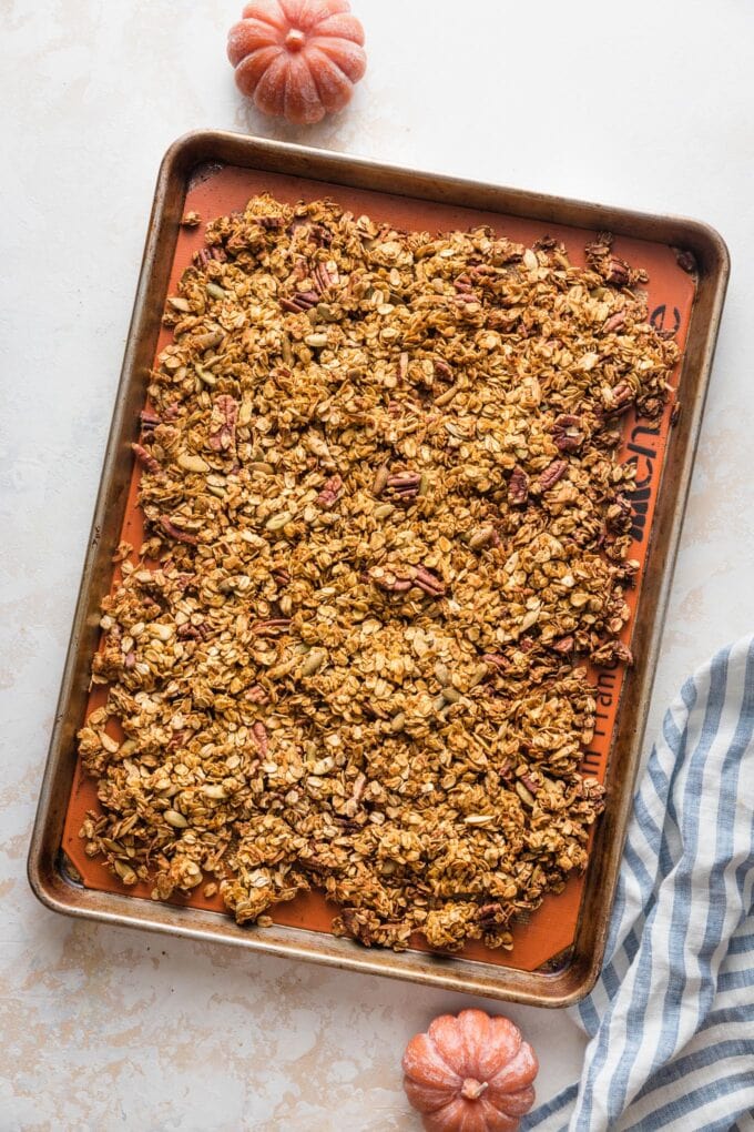 Maple pumpkin granola cooling on a baking sheet.