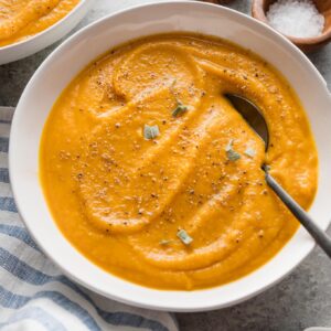 Angled view of a bowl of smooth, velvety roasted butternut squash soup.