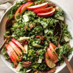 Large white ceramic bowl filled with a kale apple salad.