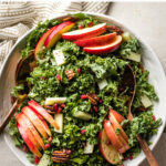 This is the best ever kale apple salad! Perfect for Thanksgiving, Christmas, or any holiday, with pecans, salty Pecorino cheese, and pomegranate seeds. It's healthy and easy to make, too, with a super simple 30-second salad dressing hack. #kalerecipes #saladrecipes