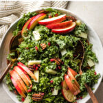 This is the best ever kale apple salad! Perfect for Thanksgiving, Christmas, or any holiday, with pecans, salty Pecorino cheese, and pomegranate seeds. It's healthy and easy to make, too, with a super simple 30-second salad dressing hack. #kalerecipes #saladrecipes