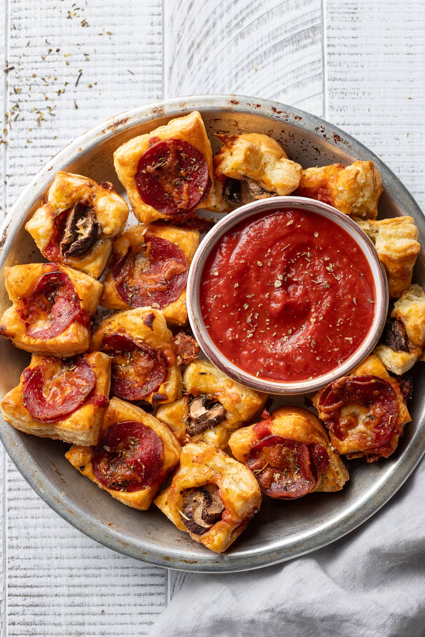 Puff pastry pizza bites with pepperoni and mushrooms served with dipping sauce.