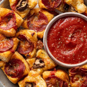 Puff pastry pizza bites with pepperoni and mushrooms served with dipping sauce.