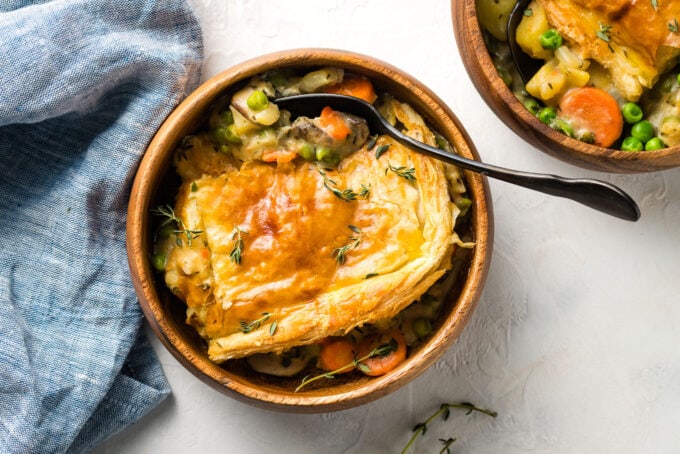 Landscape image of wooden bowls with servings of pot pie.