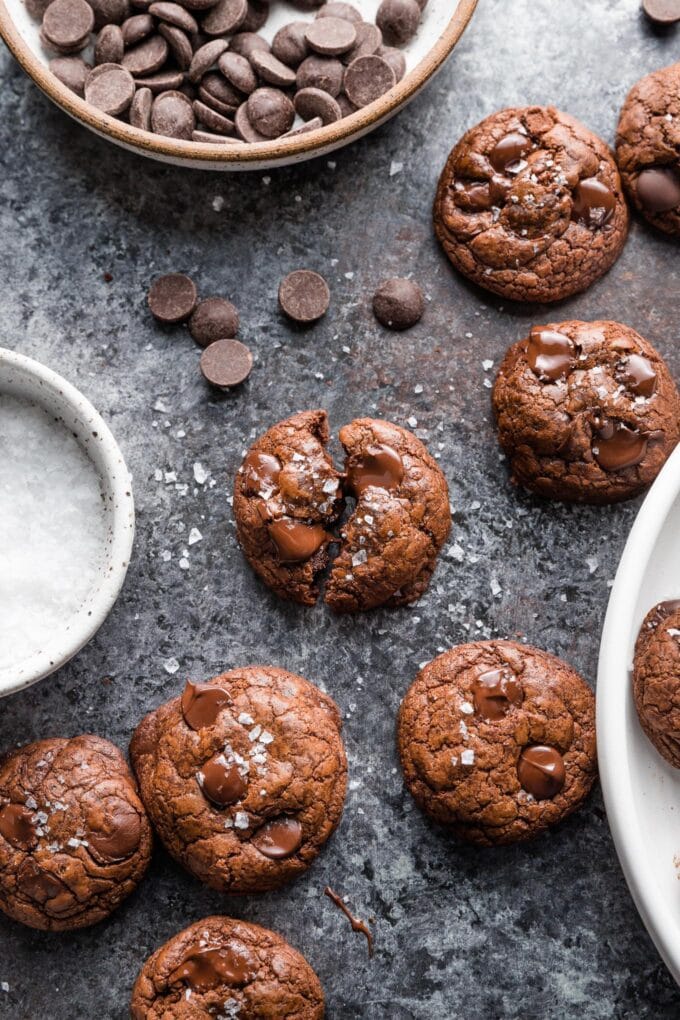 A dark chocolate chunk cookie pulled apart to show the thick texture and tons of melted chocolate as it pulls apart.