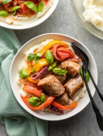 Bowls of Italian sausages, peppers, and onions served with creamy mashed potatoes.