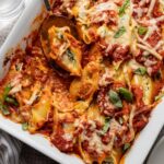 A large baking dish filled with baked stuffed shells filled with ricotta and spinach.