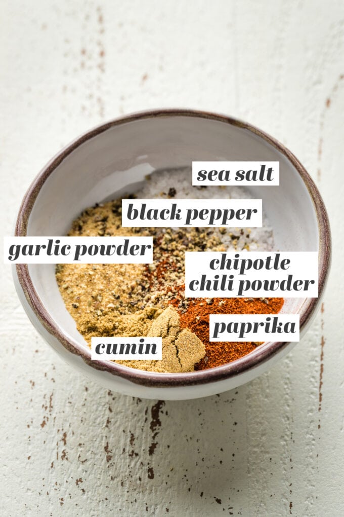 Small prep bowl containing sea salt, black pepper, garlic powder, chipotle chili powder, paprika, and cumin.