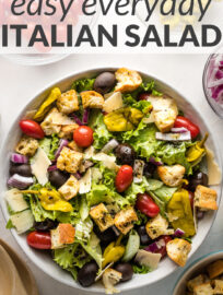 Complete your favorite meal with this easy Italian salad! Crisp greens, juicy tomatoes, tangy olives, and crunchy croutons make this a winner every time. A perfect Olive Garden dupe that is crowd-pleasing and crazy easy to customize and make at home!