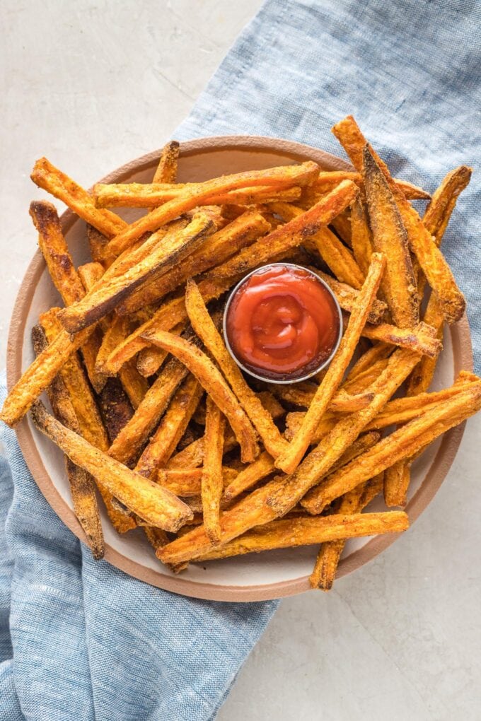 Bowl of sweet potato fries served with ketchup.