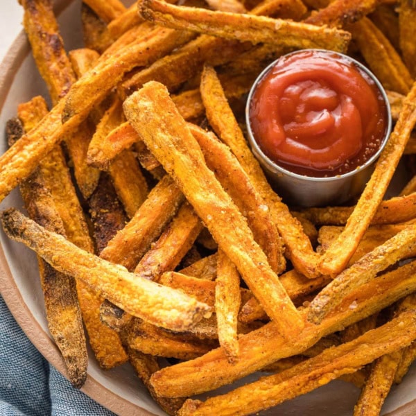 Bowl of sweet potato fries served with ketchup.