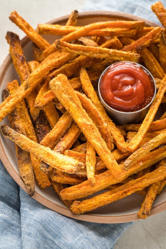 Bowl of sweet potato fries served with ketchup.