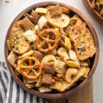 Small wooden snack bowl filled with everything bagel Chex mix.