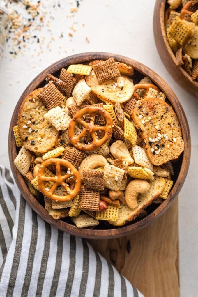 Small wooden snack bowl filled with everything bagel Chex mix.