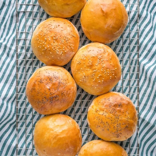 Finished hamburger buns on a cooling rack.