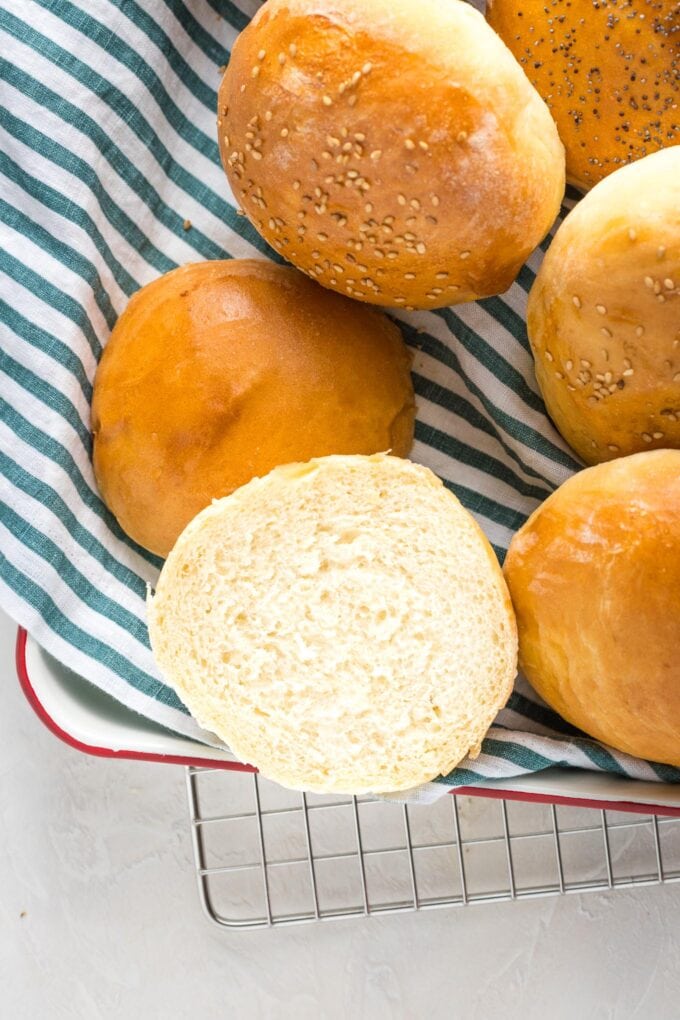 Buns on a tray with one sliced open.