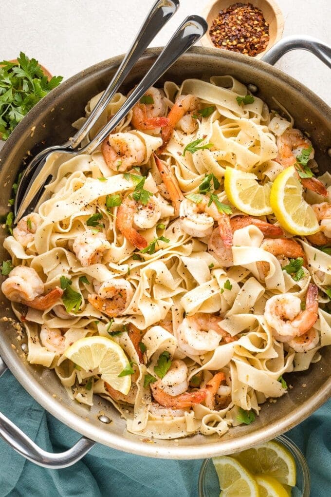 Large skillet filled with lemon pepper shrimp and pasta, ready to serve.