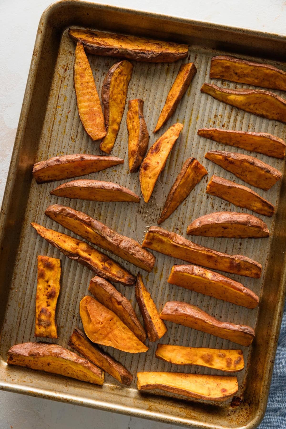 Roasted sweet potato wedges on a baking sheet.