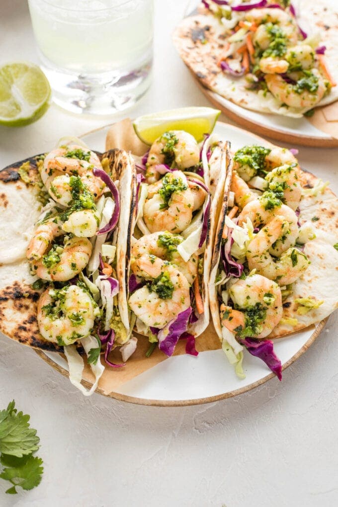 Three shrimp tacos on a small plate.