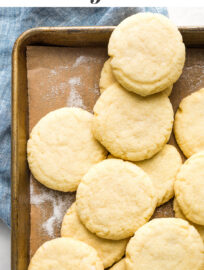 Cookies on a baking sheet with overlaid text reading: "Melt-in-your-mouth Amish Sugar Cookies"