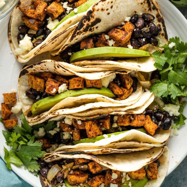 Close up of tacos on a white plate.