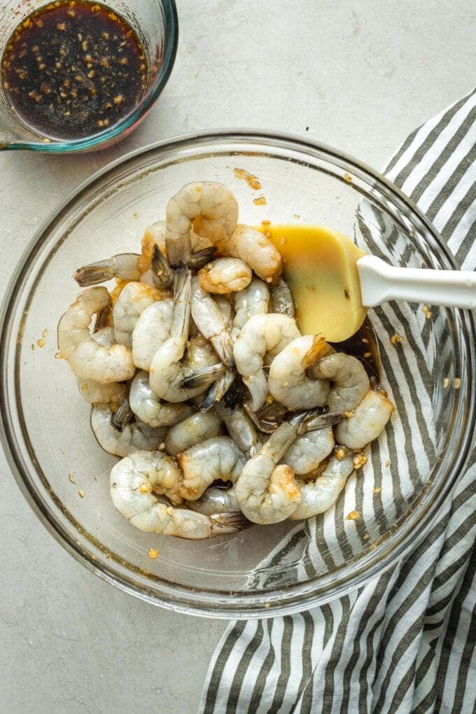 Raw shrimp in a bowl with honey garlic marinade.