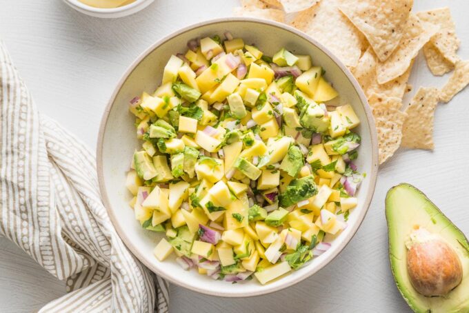 Landscape-oriented view of a bowl filled with mango avocado salsa.