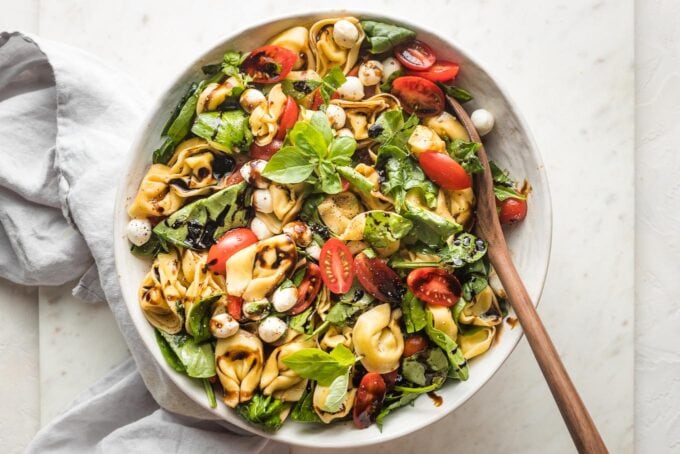 This tortellini Caprese salad is fresh, fast, and full of bright summer flavors! A simple balsamic dressing elevates these classic ingredients. Serve for a fantastic quick lunch or a barbecue side that earns rave reviews.