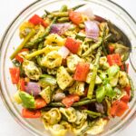 Bowl full of cheese tortellini and roasted vegetables.