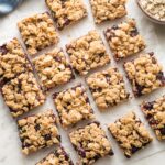 Squares of blueberry oatmeal bars arranged on parchment paper.