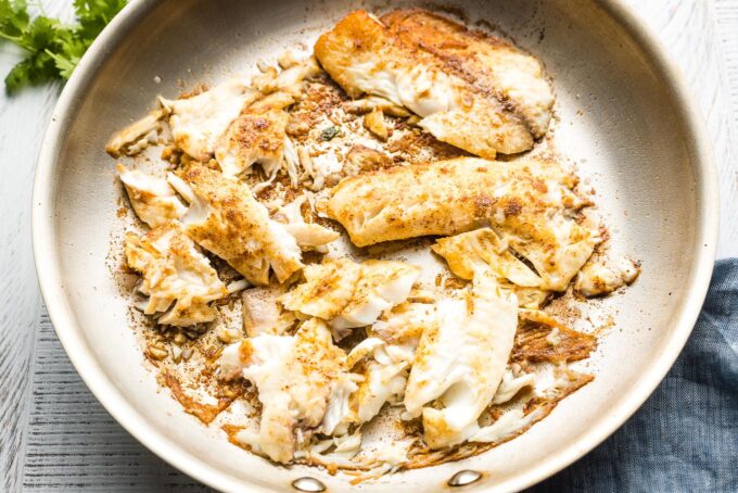 Cooked tilapia in a large skillet.