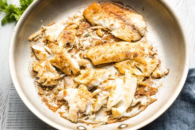 Cooked tilapia in a large skillet.
