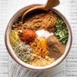 Small white bowl holding spices for Jamaican jerk seasoning.