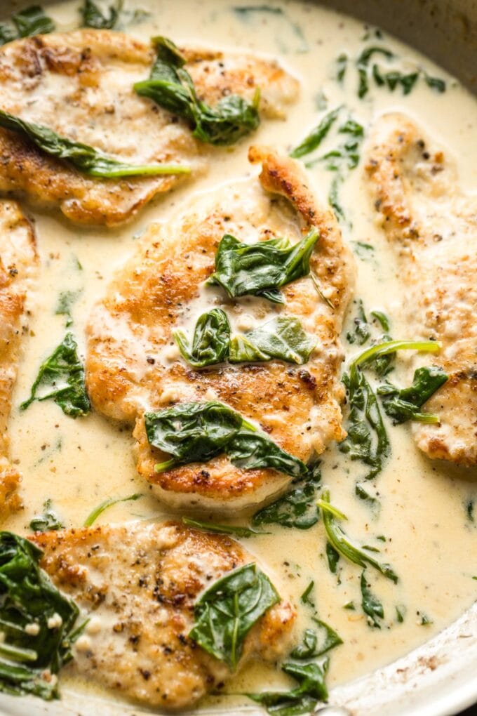 Close-up of a piece of chicken in cream sauce with spinach.