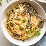 Bowl of garlic mushroom spaghetti with fresh oregano and toasted garlicky breadcrumbs.