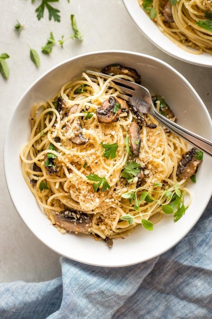 Bowl of garlic mushroom spaghetti with fresh oregano and toasted garlicky breadcrumbs.