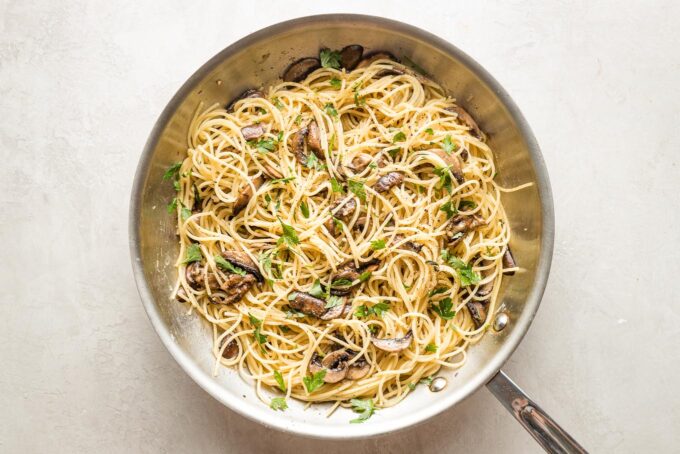 Mushrooms with herbs and spaghetti in the skillet.
