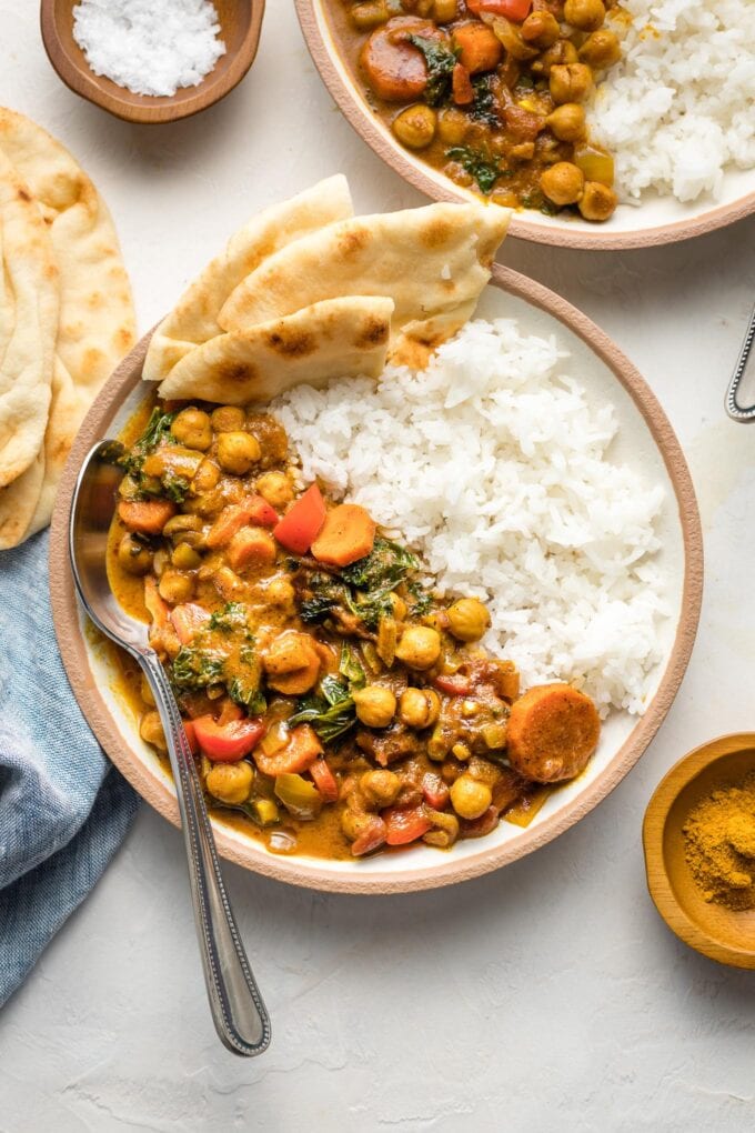 Bowl of Instant Pot chickpea curry served with rice and naan.