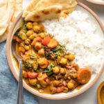 Bowl of Instant Pot chickpea curry served with rice and naan.