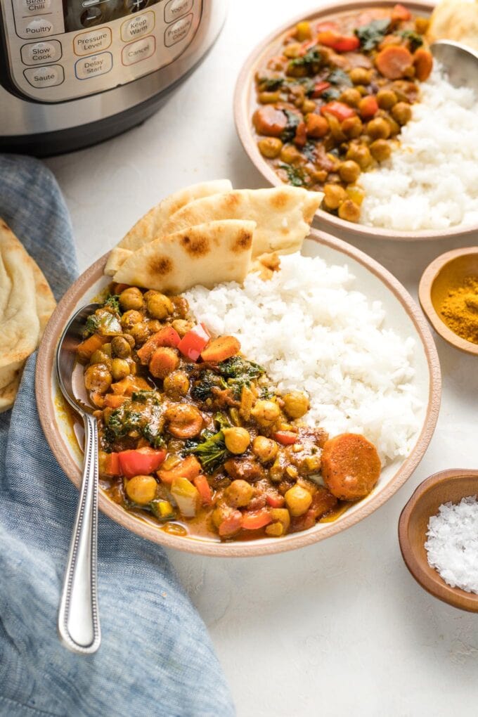 Bowl of chickpea curry with an Instant Pot in the background.